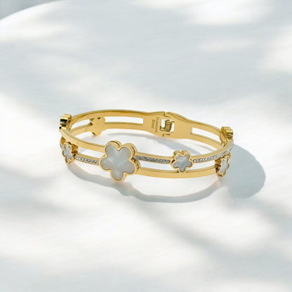 Gouden Bangle Armband met Bloemmotief en Witte Accenten